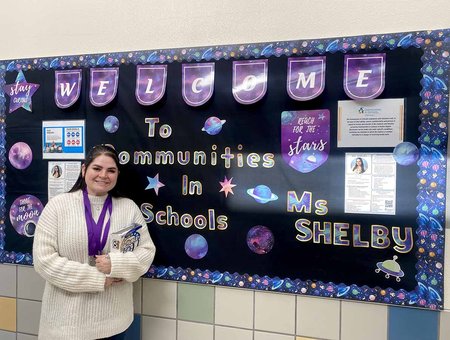 CIS Site Coordinator Shelby in front of her bulletin board
